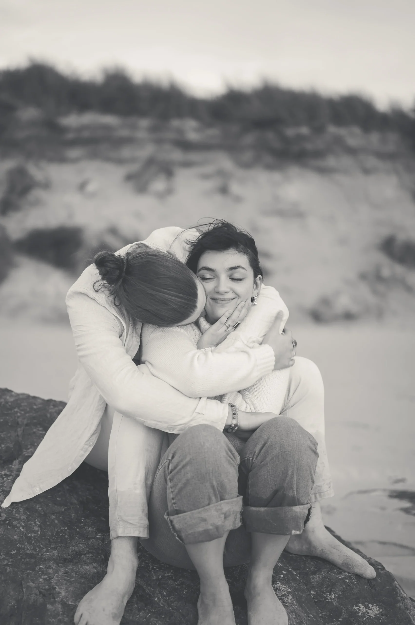 Photo-noir-et-blanc-d-un-couple-assis-sur-un-rocher-au-bord-de-la-plage-en-Bretagne