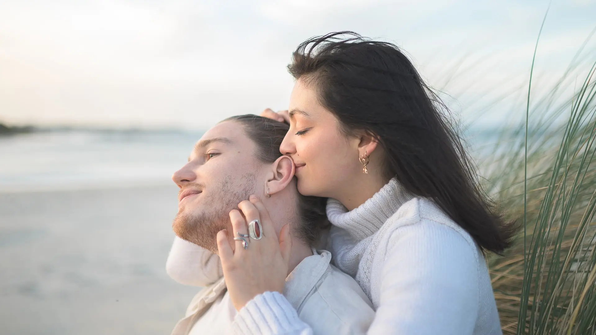 femme-embrassant-son-partenaire-sur-la-joue-dans-les-dunes-en-bretagne-moment-d-emotion