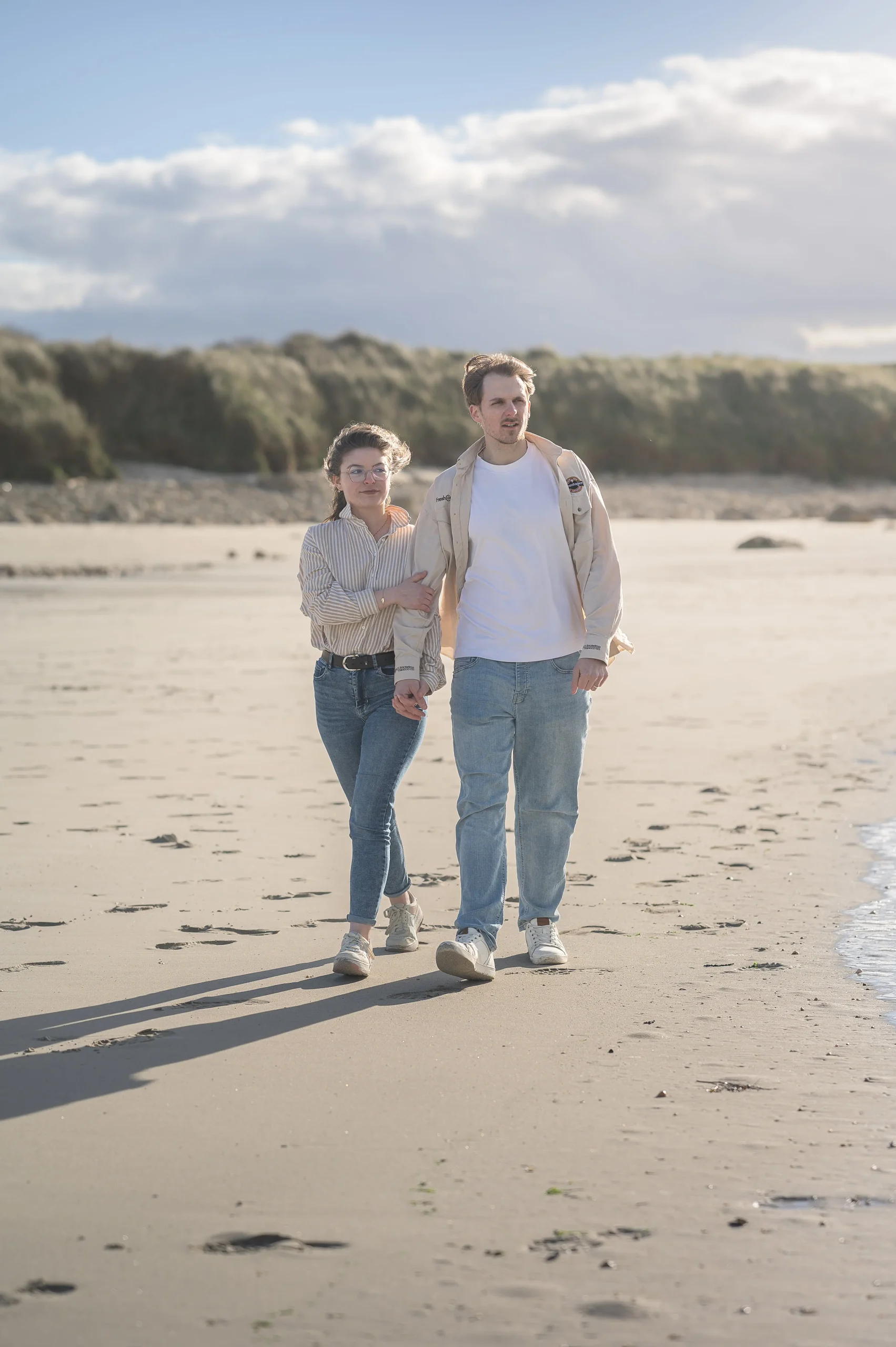lumiere-doree-sur-un-couple-marchant-main-dans-la-main-au-bord-de-l-eau