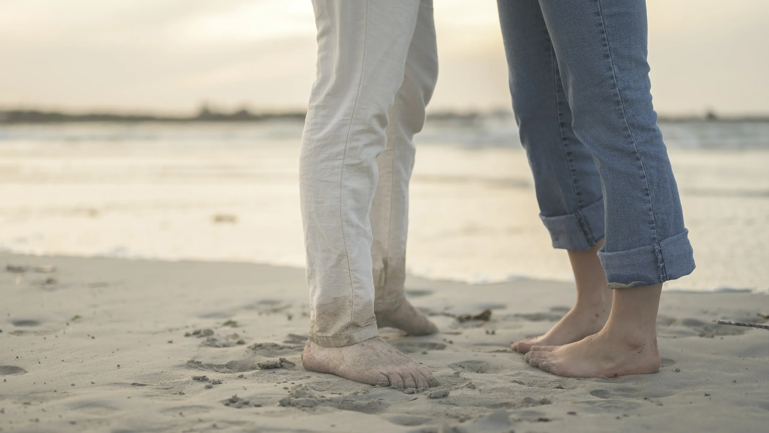 Pieds-nus-d’un-couple-se-faisant-face-sur-le-sable-mouillé-au-bord-de-l’eau-en-Bretagne