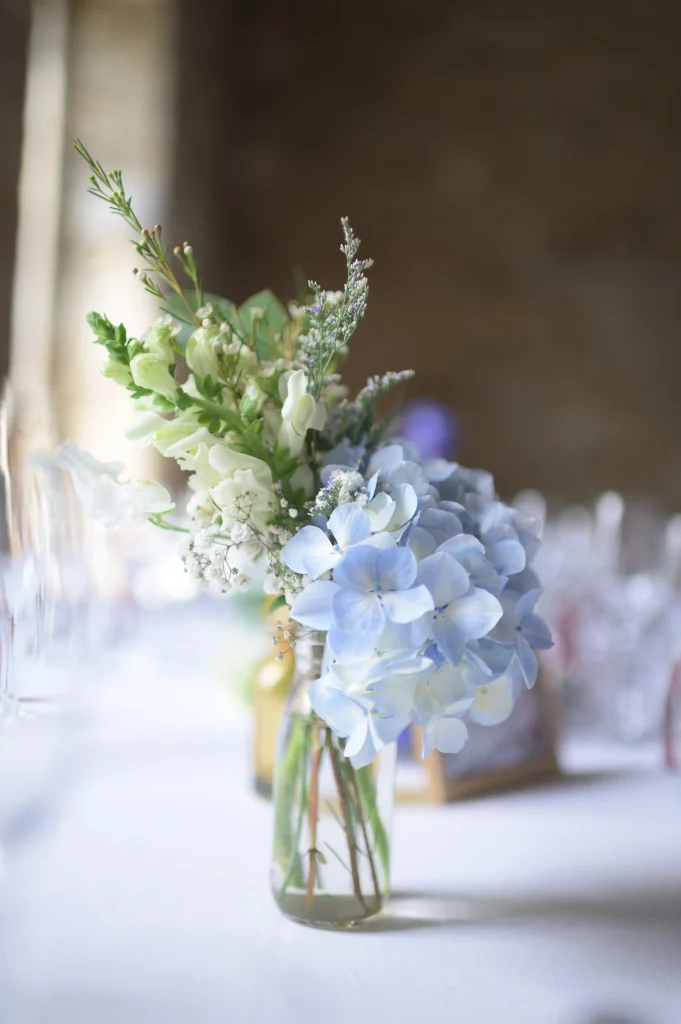 bouquet-de-fleurs-blanches-et-bleues-sur-une-table-de-mariage-au-domaine-de-lanniron-a-quimper