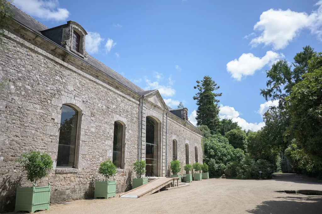 façade-en-pierre-de-lorangerie-du-domaine-de-lanniron-a-quimper-sous-un-ciel-bleu-estival